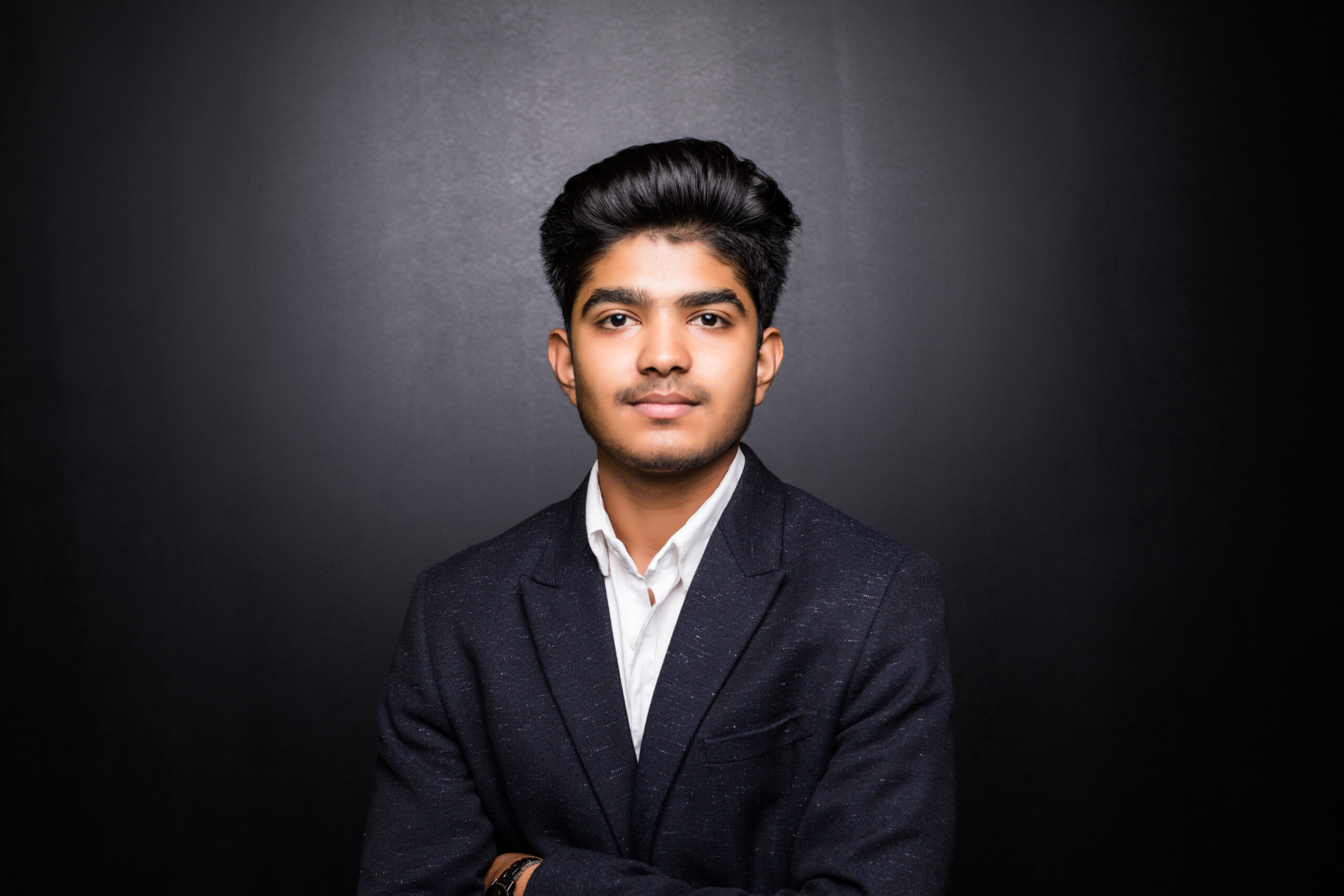 indian business man on dark background, crossed arm
